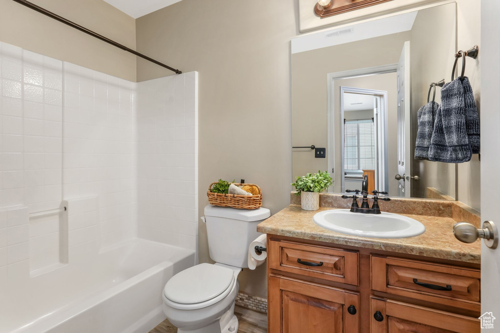 Bathroom with toilet, shower / bathing tub combination, and vanity
