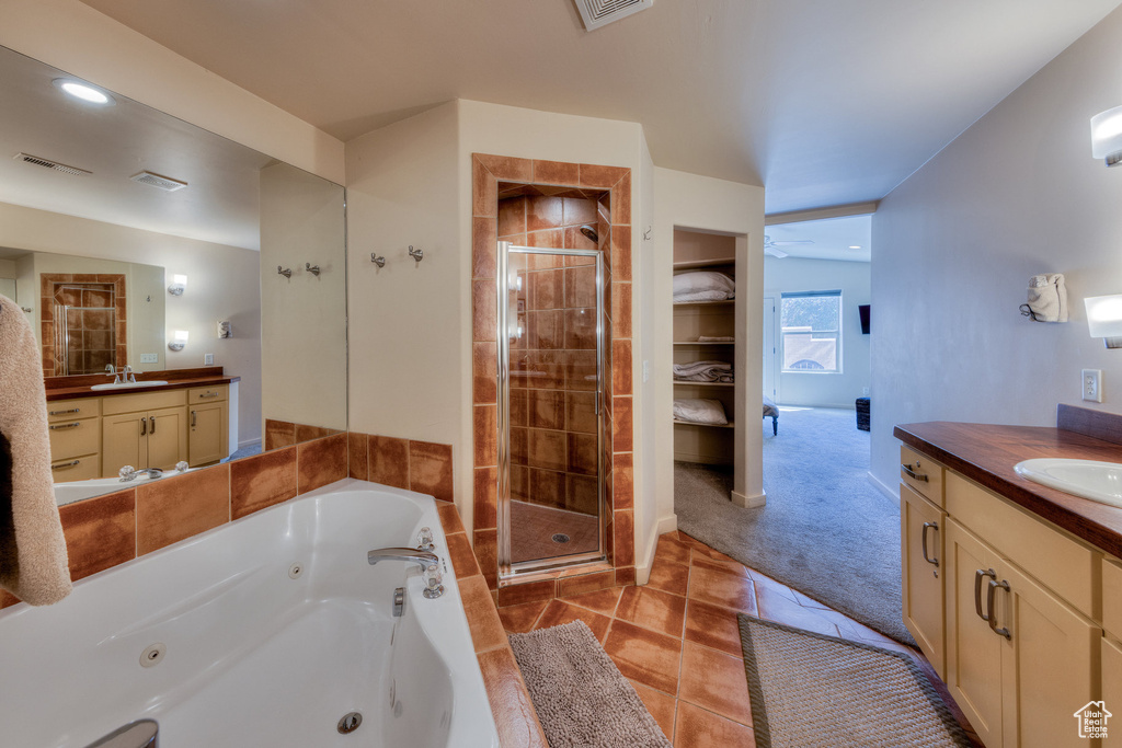 Bathroom featuring a shower stall, vanity, and visible vents