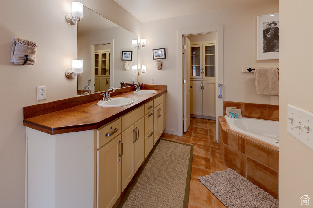 Full bathroom featuring tile patterned flooring, a garden tub, and a sink