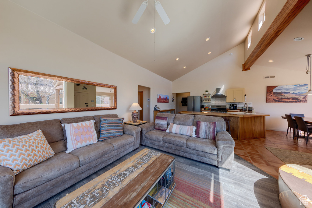 Living room featuring high vaulted ceiling, recessed lighting, ceiling fan, beamed ceiling, and baseboards