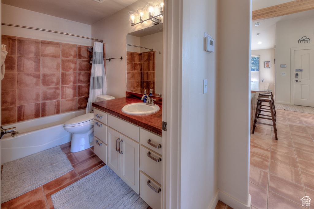 Full bathroom featuring tile patterned floors, toilet, shower / tub combo, and vanity