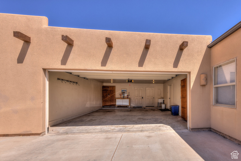Exterior space with concrete driveway, a patio area, and stucco siding