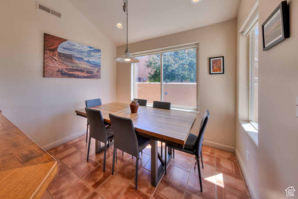 Tiled dining space with vaulted ceiling, baseboards, visible vents, and recessed lighting