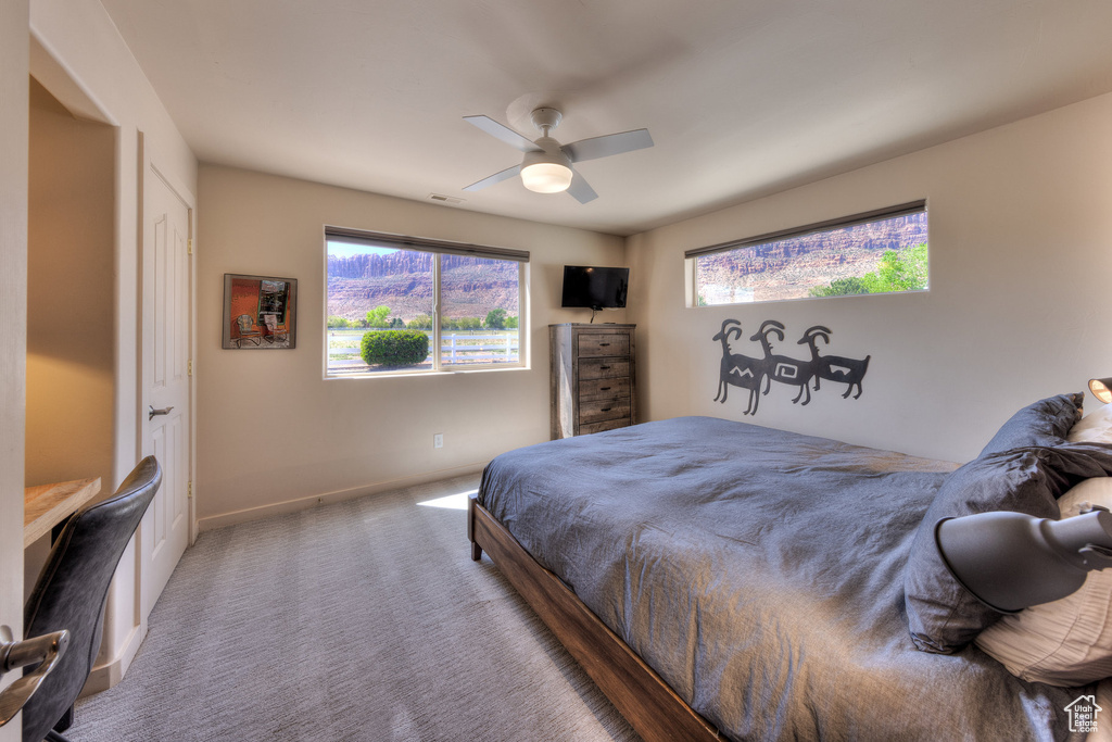 Bedroom featuring carpet, baseboards, a ceiling fan, and visible vents