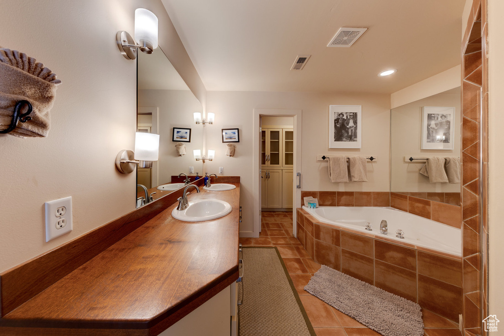Bathroom with a sink, a garden tub, and visible vents