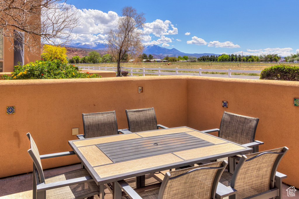 View of patio with fence, outdoor dining area, a mountain view, and a rural view