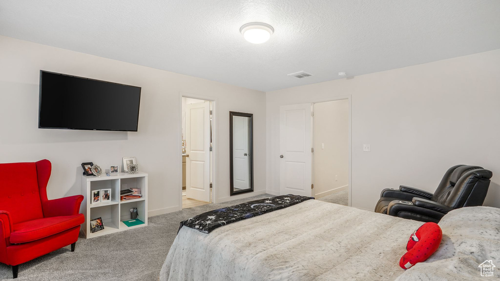 Carpeted bedroom with baseboards and visible vents