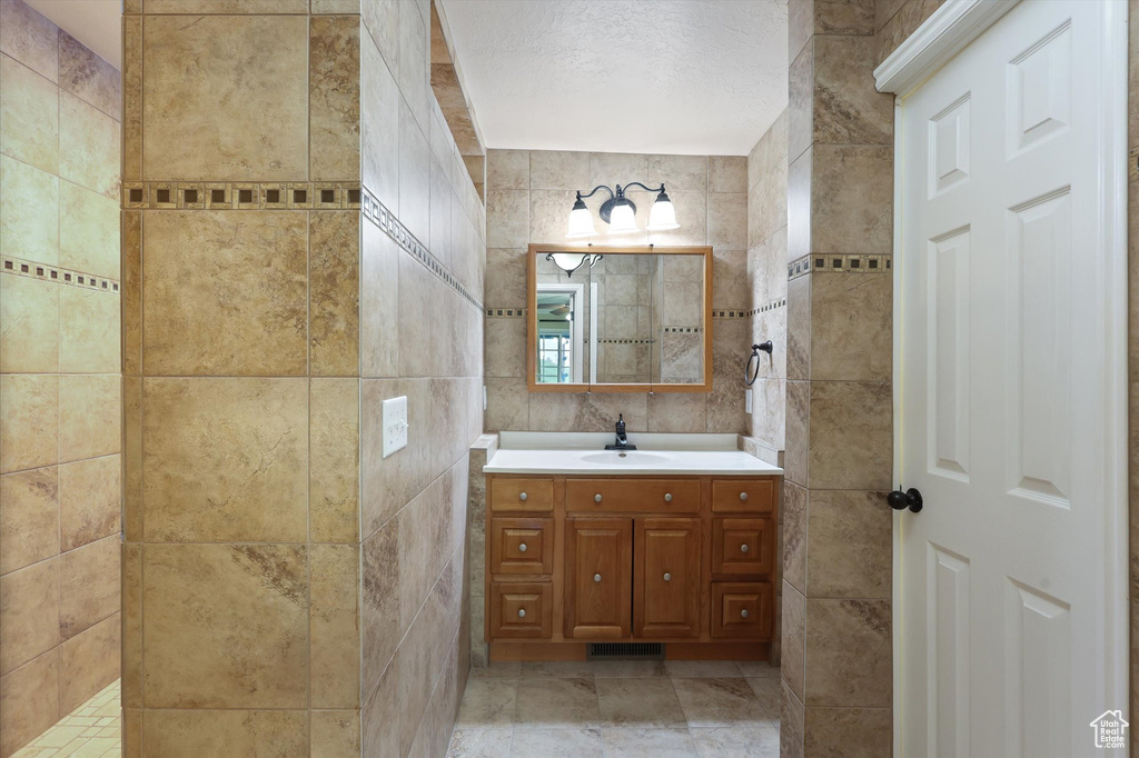 Bathroom with tile walls and vanity