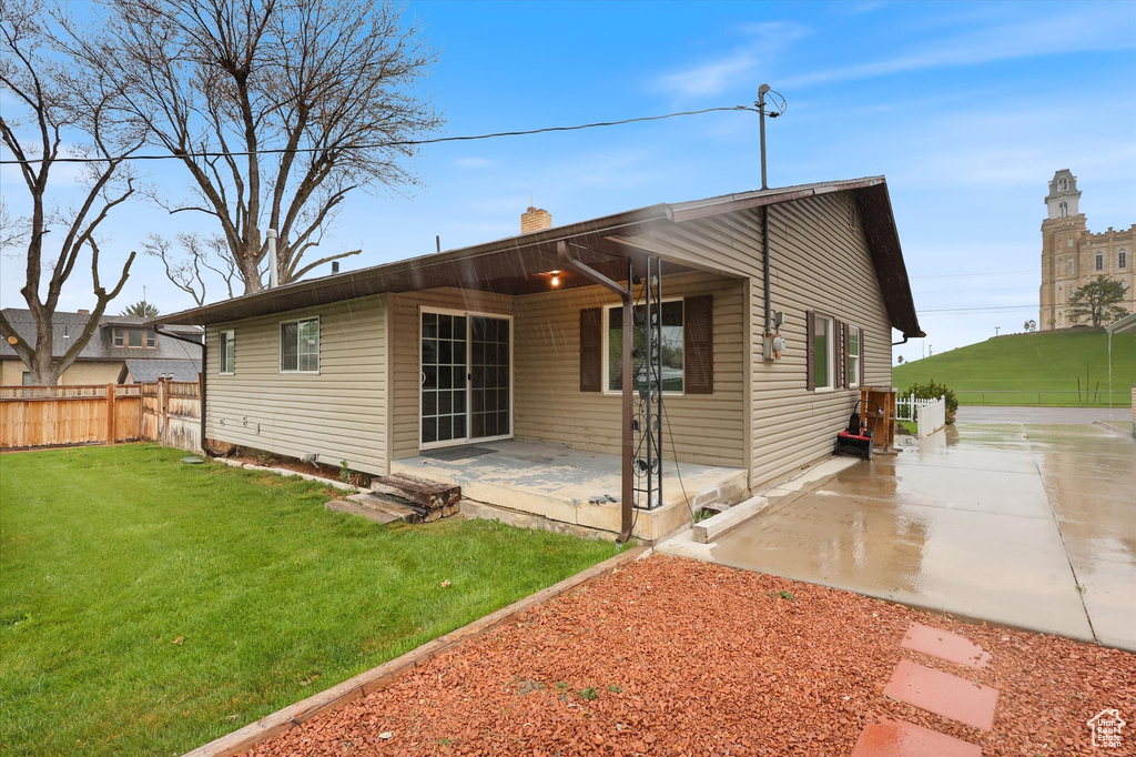 Rear view of house with a yard, a patio area, a chimney, and fence