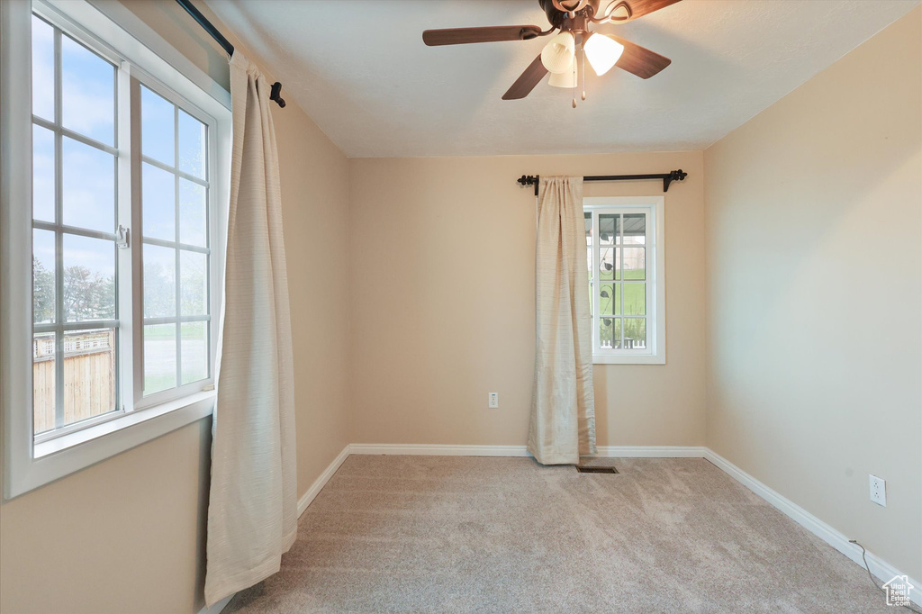 Empty room featuring a ceiling fan, carpet flooring, and baseboards
