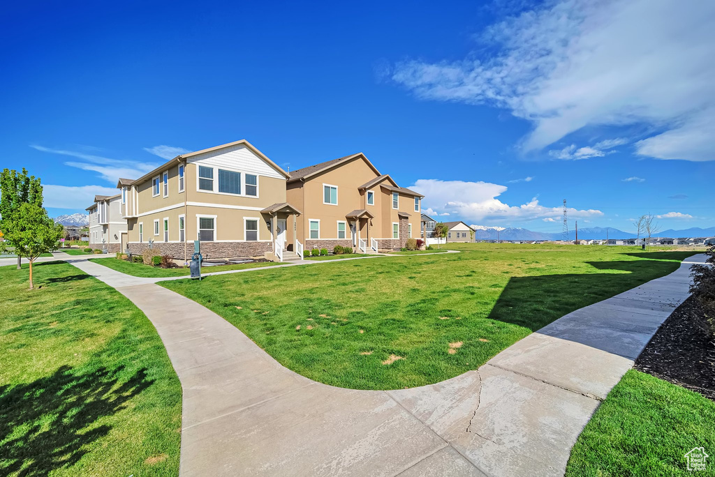 Surrounding community with a mountain view and a yard