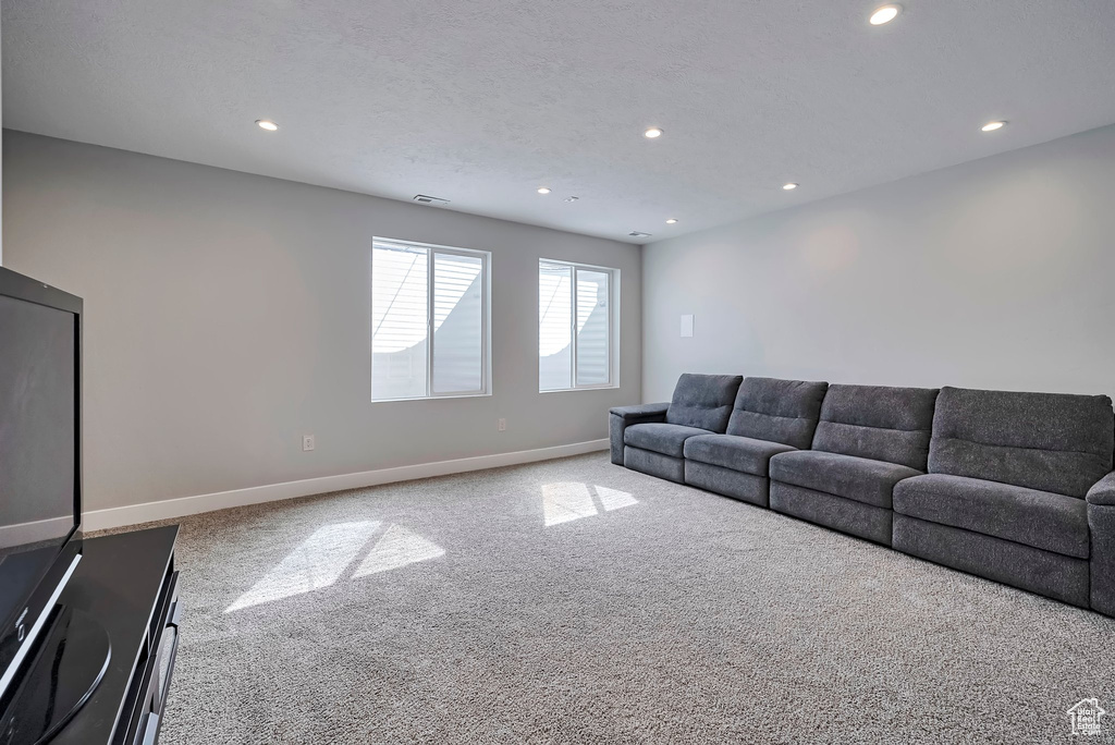 Living area featuring carpet floors, baseboards, recessed lighting, and visible vents