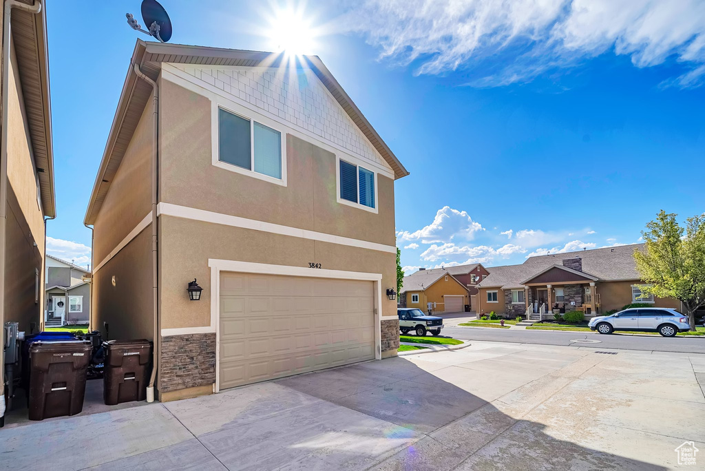 View of home\\\\\\\\\\\\\\\\\\\\\\\\\\\\\\\'s exterior featuring an attached garage, a residential view, stone siding, and stucco siding