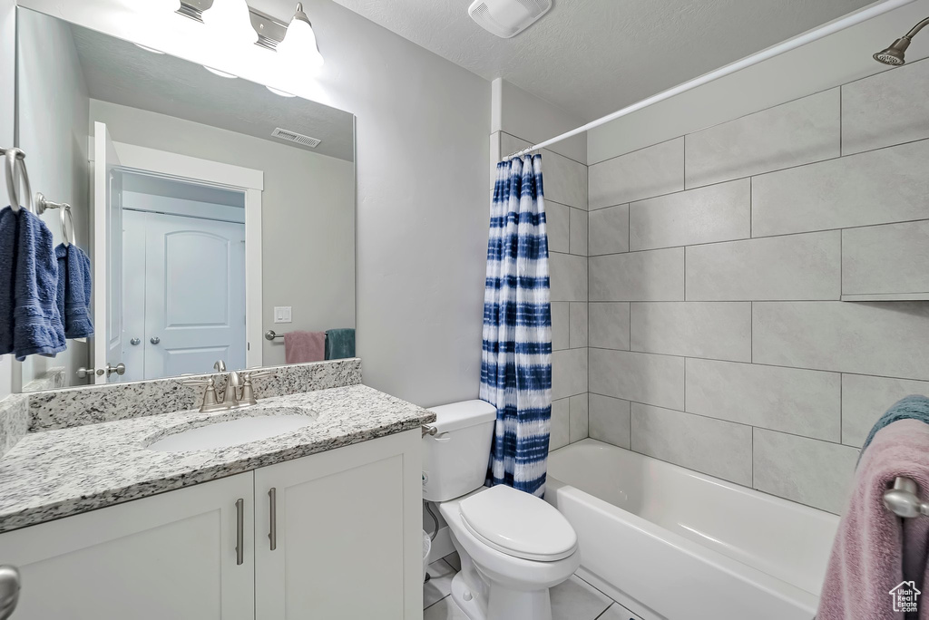 Bathroom with toilet, visible vents, shower / bath combo with shower curtain, and vanity