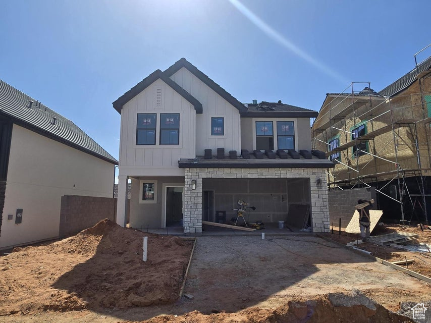 Back of property featuring driveway and board and batten siding