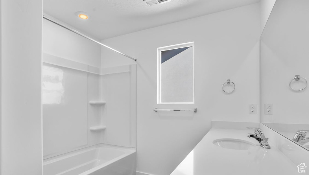 Bathroom featuring vanity, tub / shower combination, and visible vents