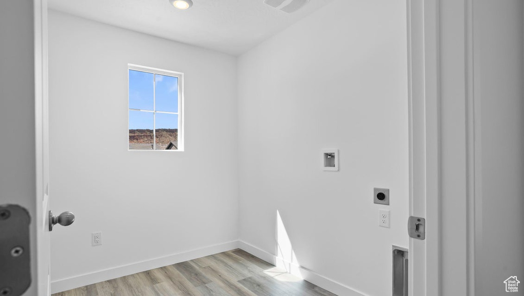 Clothes washing area featuring light wood-style flooring, baseboards, hookup for a washing machine, laundry area, and electric dryer hookup
