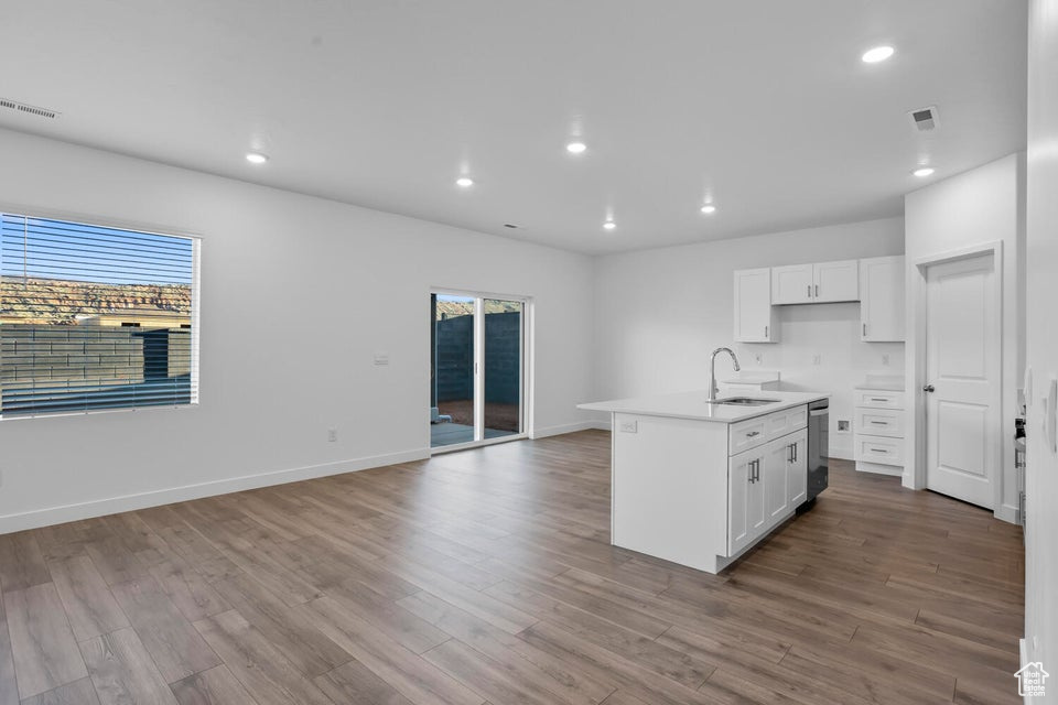 Kitchen with white cabinetry, visible vents, and a sink