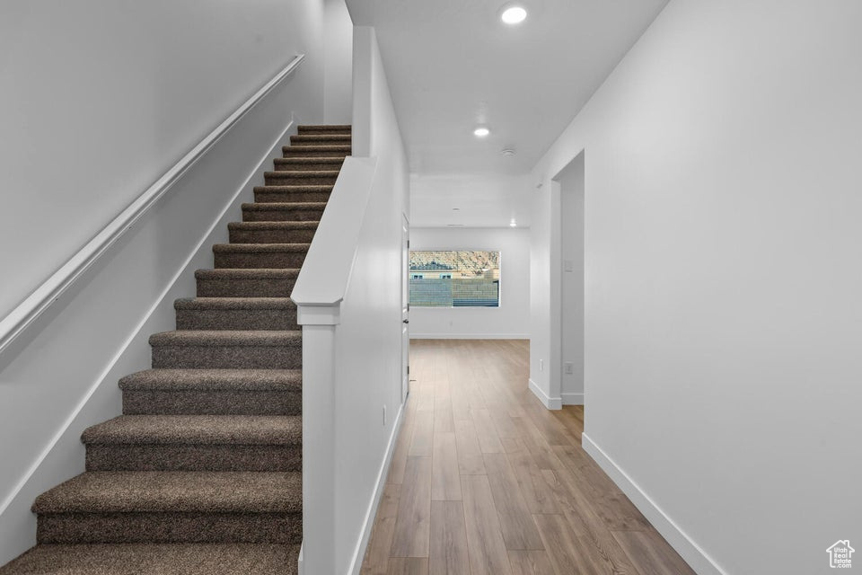 Stairs with baseboards, recessed lighting, and wood finished floors