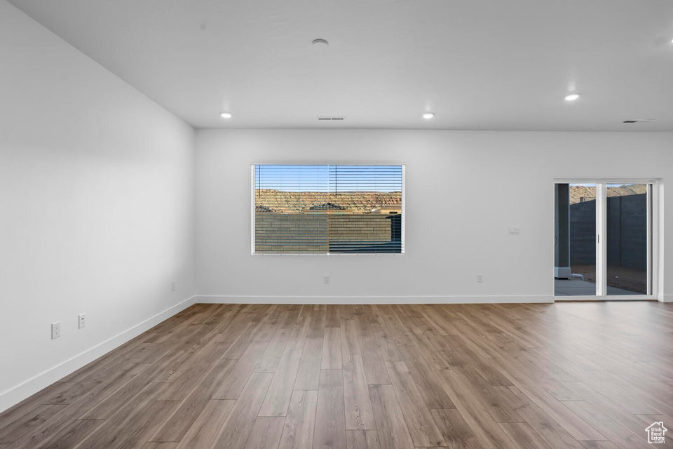 Empty room featuring recessed lighting, plenty of natural light, and wood finished floors