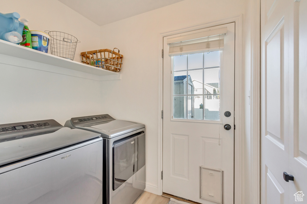 Laundry room featuring laundry area, washer and clothes dryer, and light wood-style flooring