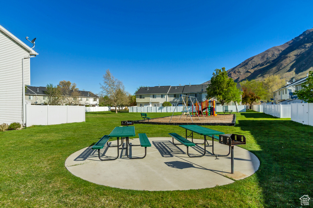 View of property\\\\\\\'s community featuring a lawn, a residential view, playground community, and fence