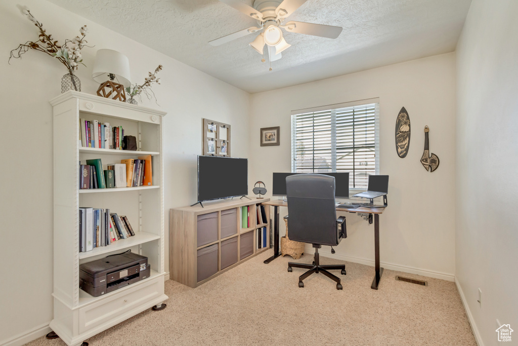 Office featuring carpet flooring, a ceiling fan, a textured ceiling, visible vents, and baseboards