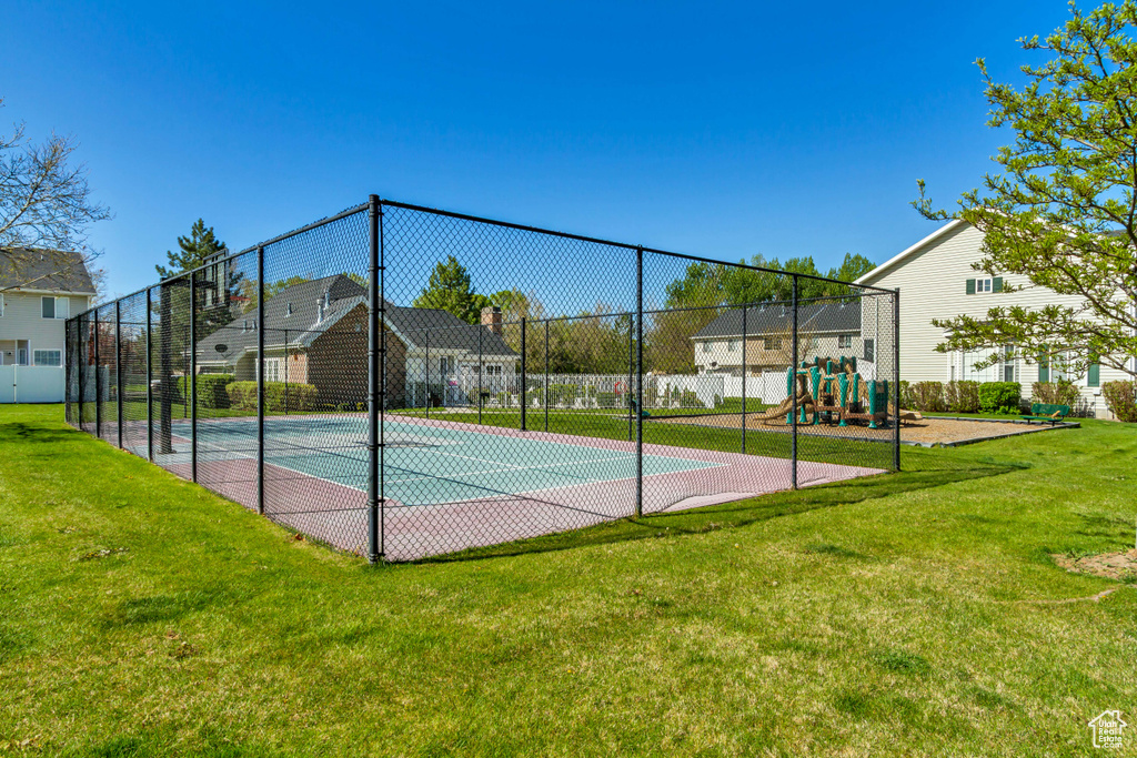 View of basketball court with a yard, fence, playground community, and a residential view