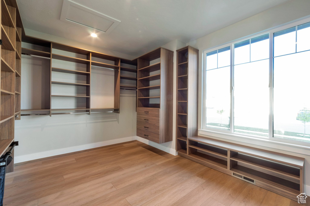 Spacious closet featuring attic access, light wood-style floors, and visible vents