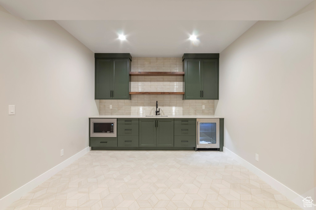 Bar featuring recessed lighting, beverage cooler, stainless steel microwave, a sink, and tasteful backsplash