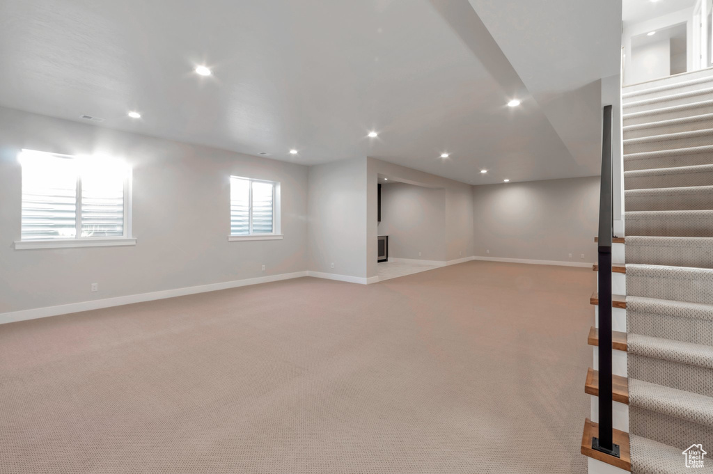 Basement with light carpet, baseboards, and recessed lighting