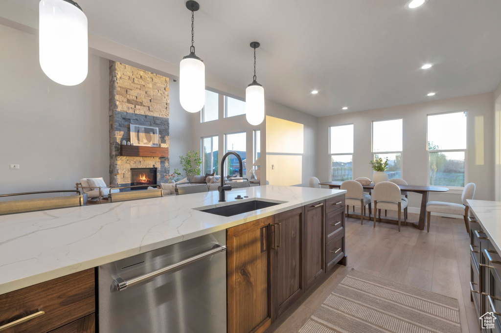 Kitchen with a sink, a fireplace, open floor plan, stainless steel dishwasher, and recessed lighting