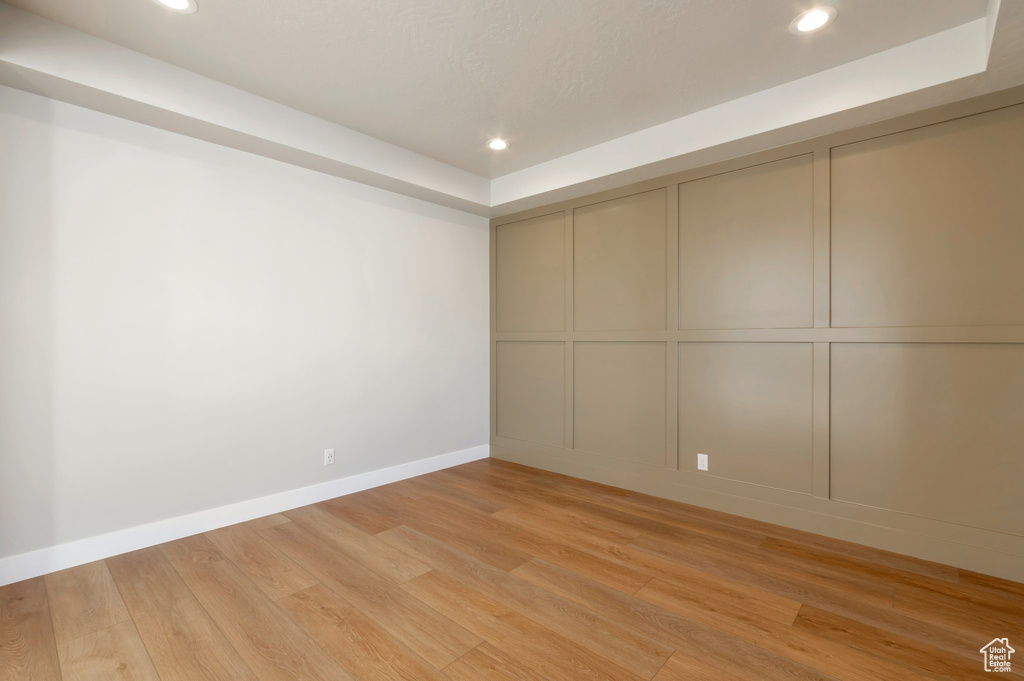 Unfurnished room with recessed lighting, a decorative wall, and light wood-type flooring