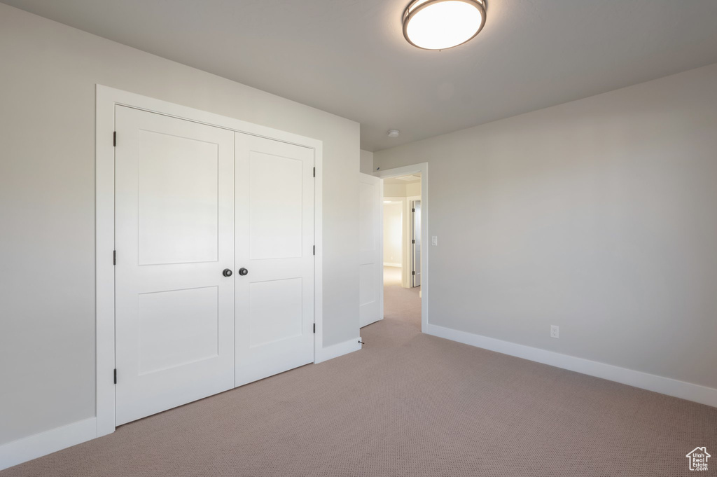 Unfurnished bedroom with carpet flooring, a closet, and baseboards