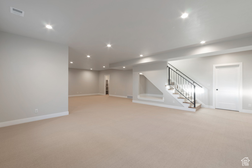 Basement featuring stairs, recessed lighting, visible vents, and light colored carpet