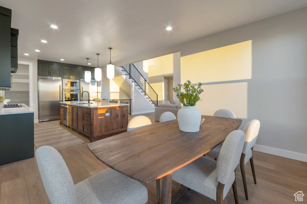 Dining room with baseboards, stairway, recessed lighting, and light wood-style floors