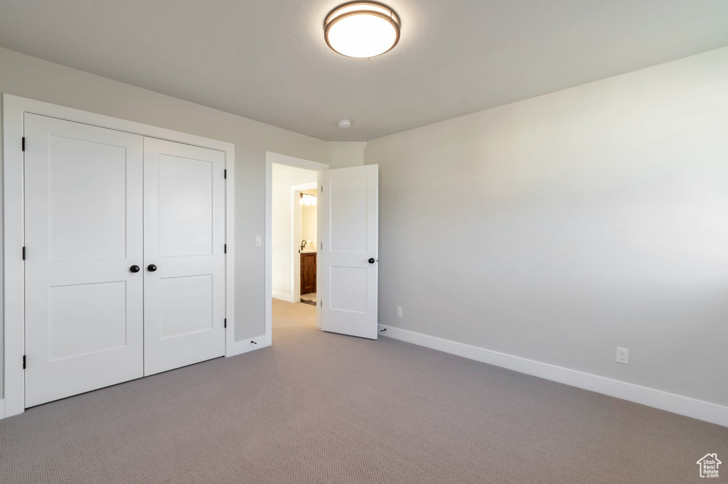 Unfurnished bedroom with carpet floors, baseboards, and a closet