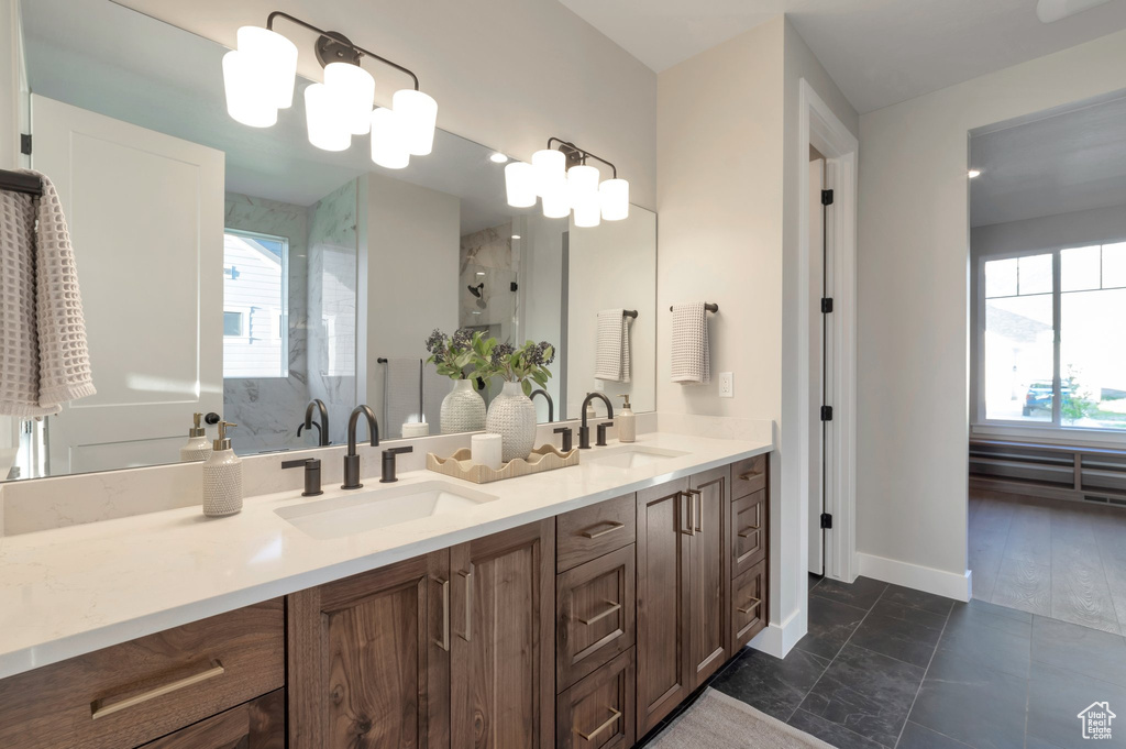 Bathroom with an enclosed shower, plenty of natural light, and a sink