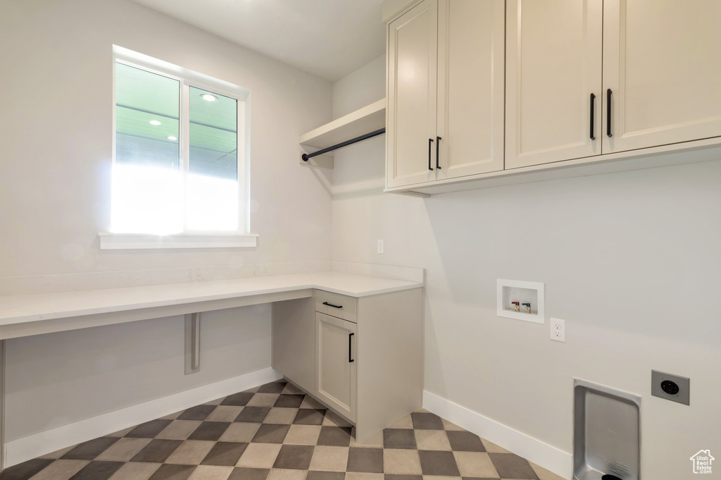 Laundry area with electric dryer hookup, baseboards, hookup for a washing machine, cabinet space, and dark floors