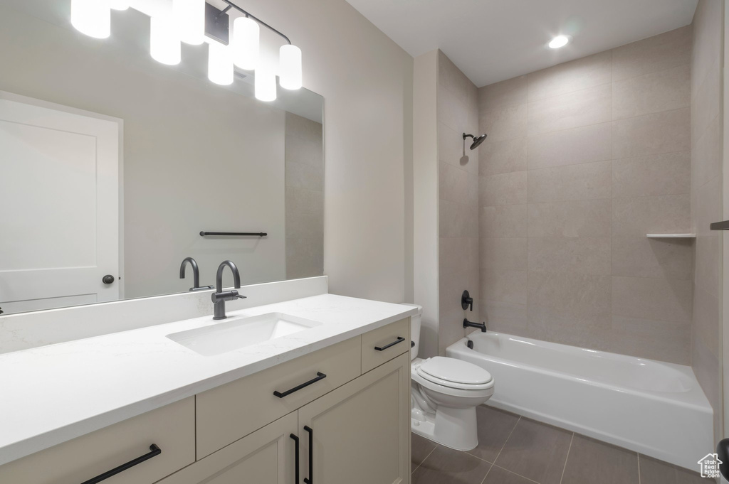 Bathroom with toilet, tile patterned flooring, bathing tub / shower combination, and vanity