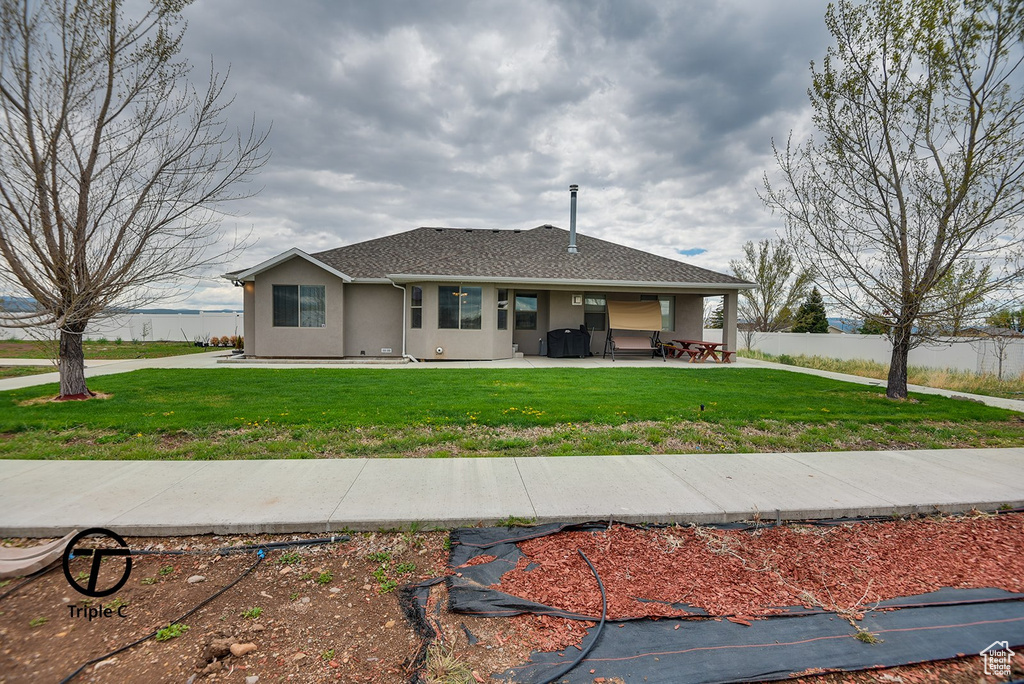 Single story home featuring stucco siding, a patio area, and a shingled roof
