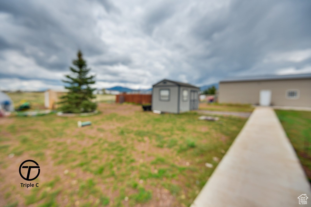 View of yard featuring a storage unit and an outbuilding