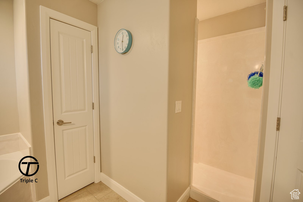 Full bath with baseboards, tile patterned flooring, a shower, and a bath