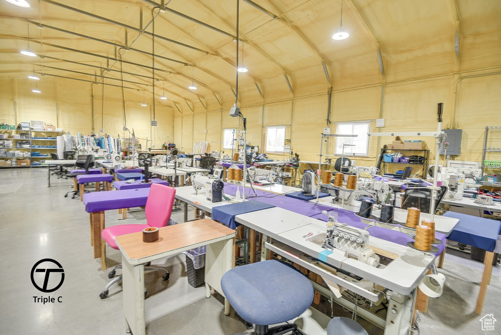 Misc room with a workshop area, concrete flooring, and lofted ceiling