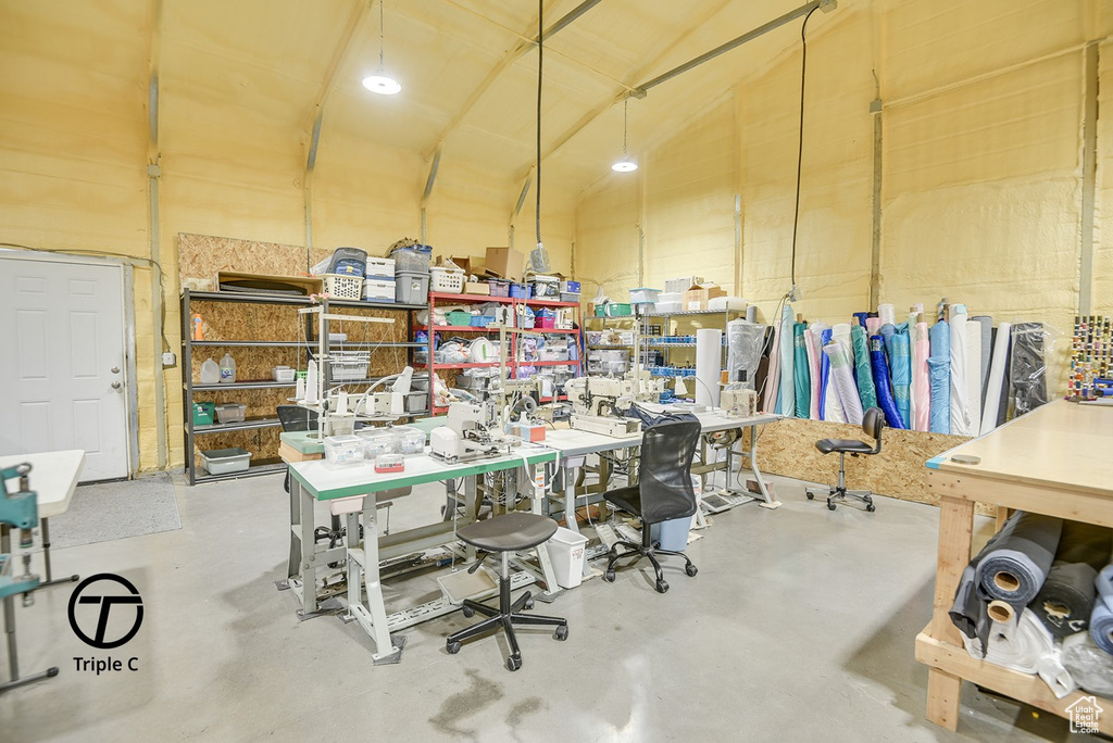 Home office featuring finished concrete flooring and vaulted ceiling