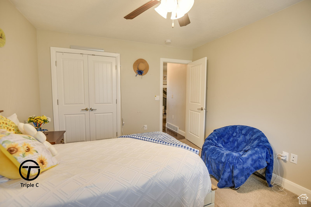 Carpeted bedroom featuring a closet, visible vents, baseboards, and a ceiling fan
