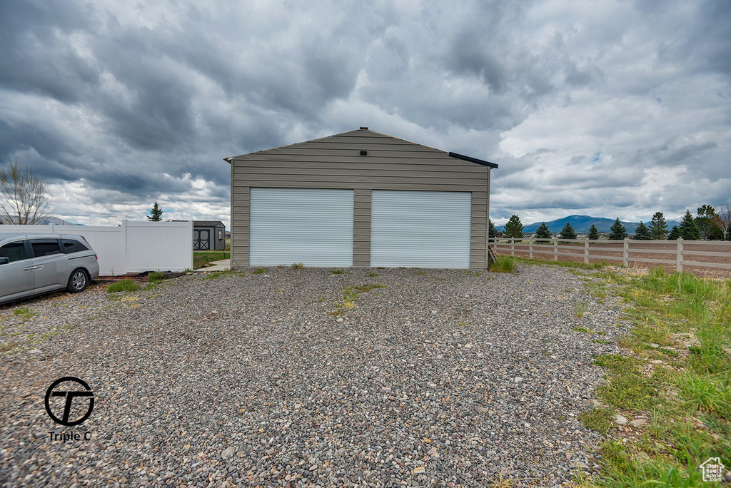 Detached garage with fence and a mountain view