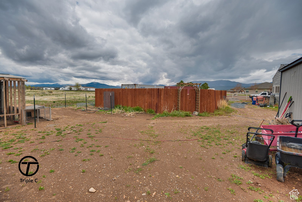 View of yard featuring fence and a mountain view