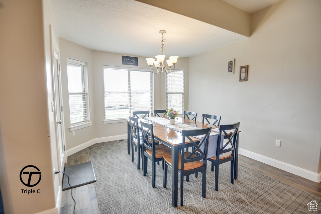 Dining area with a chandelier, baseboards, and wood finished floors