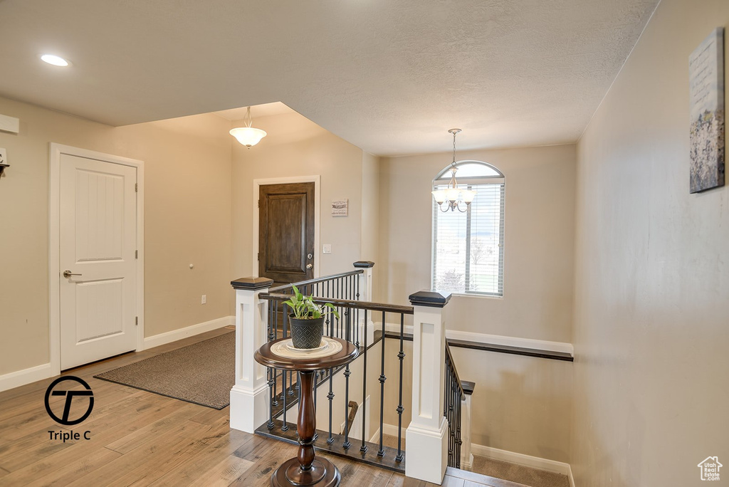 Interior space with wood finished floors, an upstairs landing, baseboards, and recessed lighting